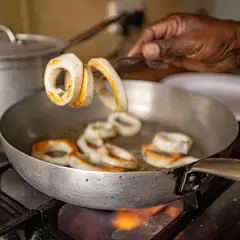 Calamari frying in a pan on the kitchen stove