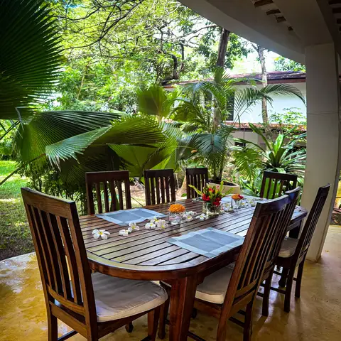 The covered porch dining table set among the gardens