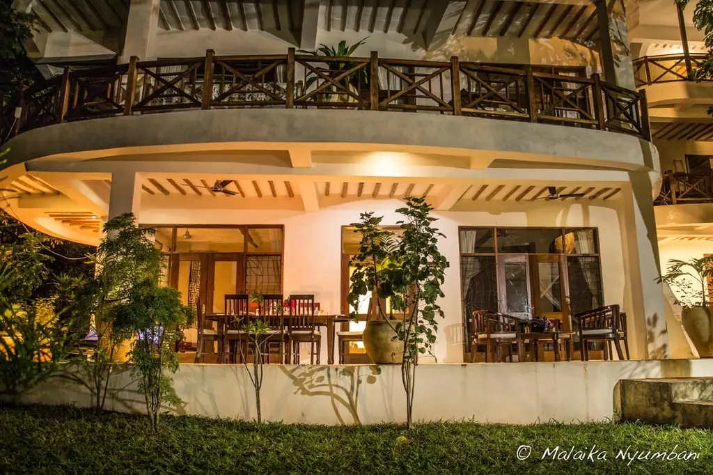 The apartment lit warm at dusk — veranda and dining table